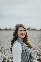 smiling woman standing in a cotton field 