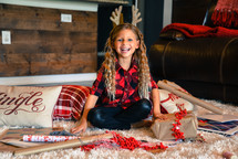 smiling little girl wrapping a Christmas present 