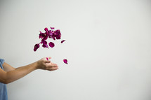 hands tossing up rose petals 
