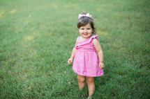 smiling toddler girl in green grass