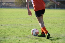 a girl dribbling a soccer ball 