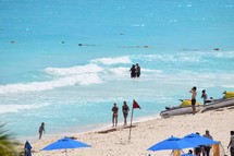 people walking on a beach and jet skis in Cancun