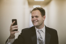 A smiling young man looking at his phone