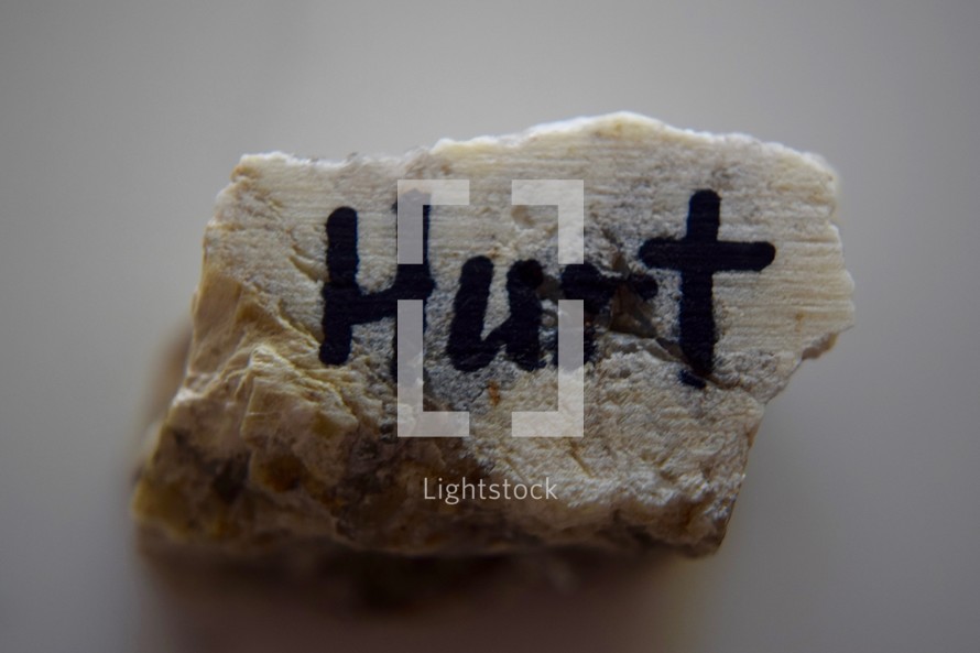 word Hurt written on a rock 