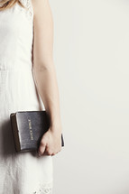 Woman holding a Bible by her side.