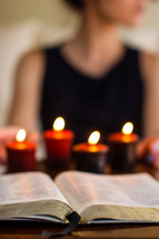 woman, open Bible, burring candles