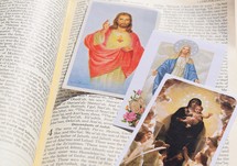 Catholic prayer cards on the pages of a Bible 
