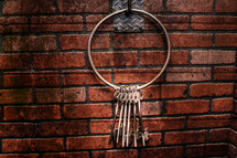 skeleton keys on a key ring against a brick wall 