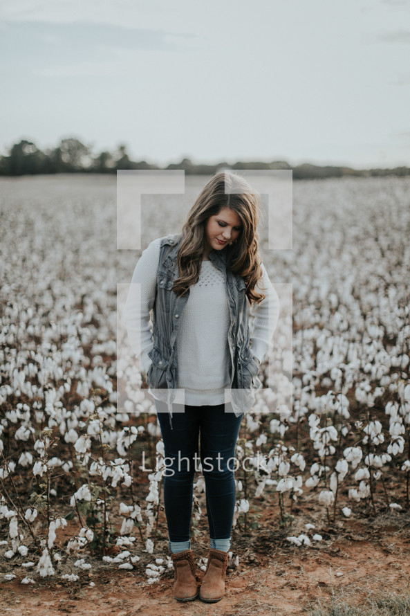 a woman standing in a field of cotton 