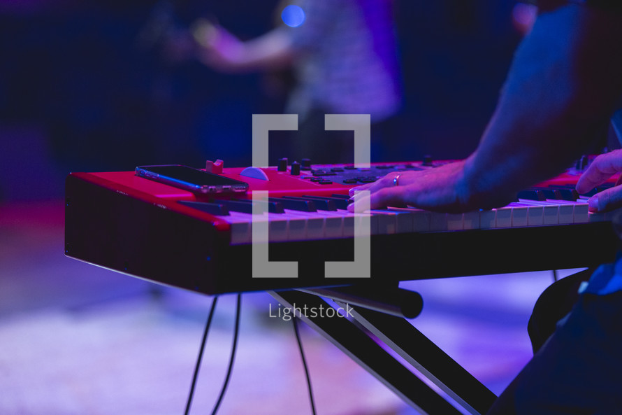 hands on a keyboard at a concert 