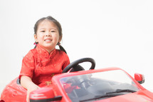 a little girl in a toy car 