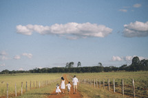 a family walking on dirt road 