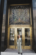 a woman standing in front of a downtown building 