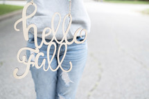 woman holding a hello fall sign 