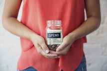 woman holding a spend money jar