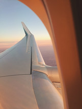 wing of a plane out an airplane window 