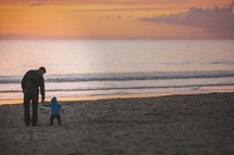 father and toddler son on a beach in fall 