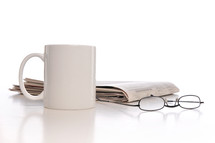 coffee mug, newspaper, and reading glasses 