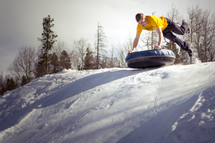 a man tubbing on a snowy hill 