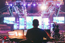 a man behind a sound booth at a concert 