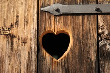 heart shape carved into a wood door 