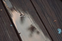 refection of the sky in puddles after the rain on wet deck boards 