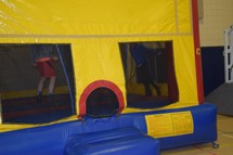 boys jumping in a bouncy house at a festival 
