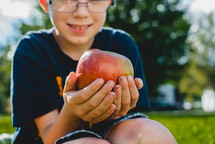 a boy holding an apple 