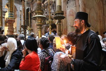worshipers, prayers, and candles in a church in Jerusalem 