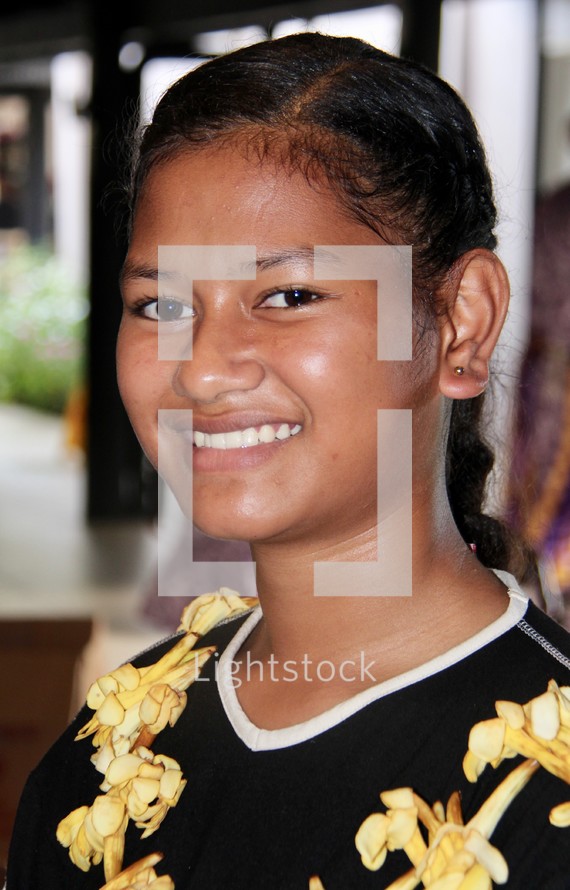 a smiling teen girl wearing a lei 