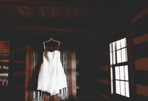 short white dress hanging on a closet door