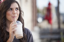 woman drinking an iced coffee