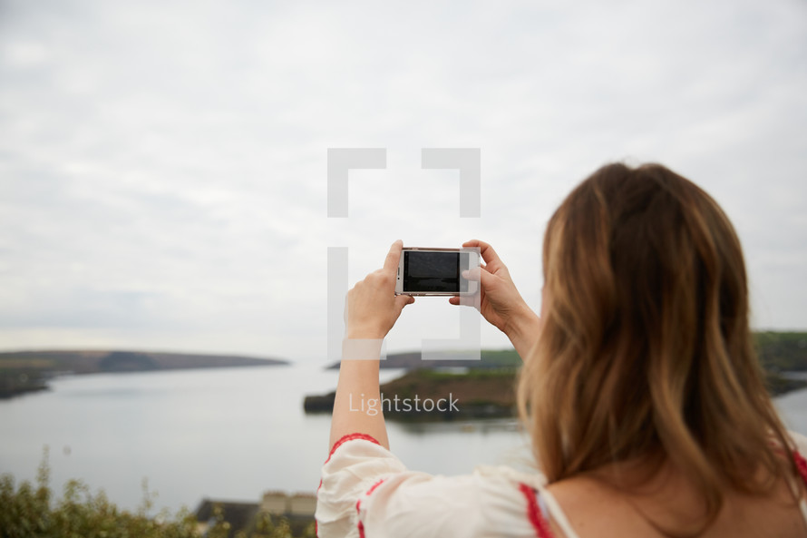 a woman taking a picture with her smartphone 