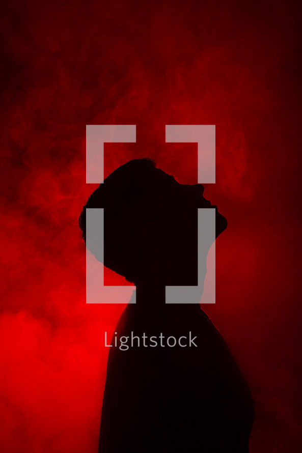 a man looking up to God standing in red glowing light 