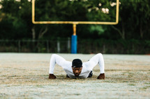 a man doing pushups on a sports field 