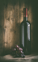 wine bottle and grapes on burlap 