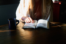 a woman reading a Bible over coffee