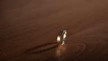 Gold ring on wooden background with place for text
