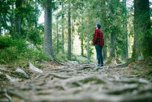 a man standing in a forest and looking up 