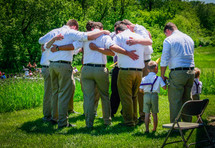 groomsmen praying before a wedding 