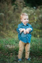 a toddler boy in the grass in fall 