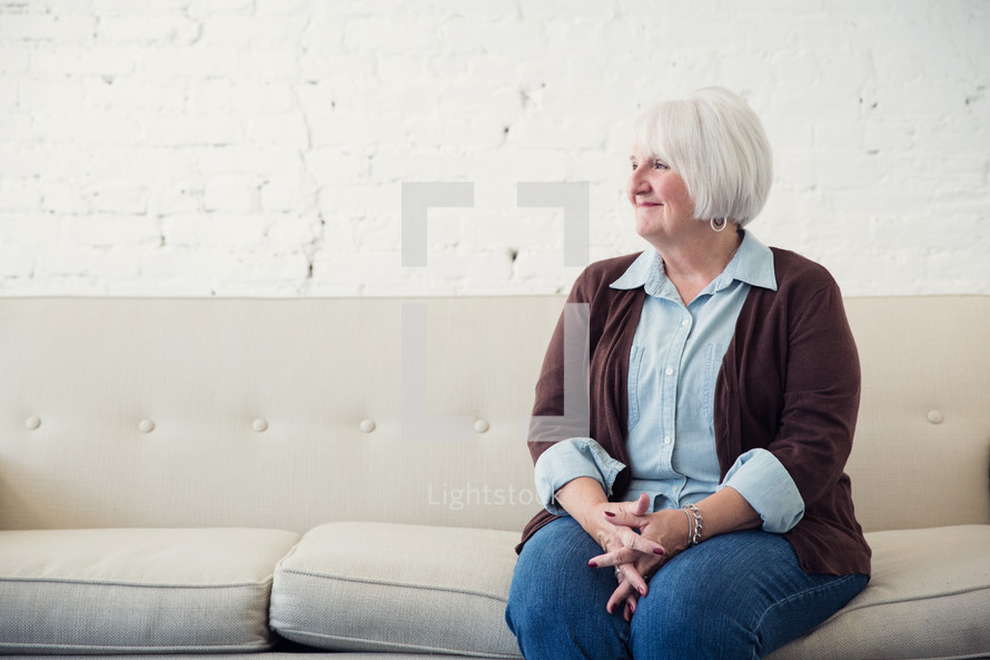 a woman sitting on a couch waiting 