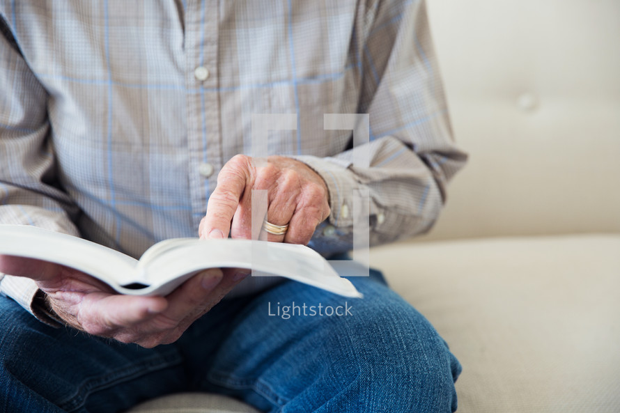 man sitting reading a Bible 