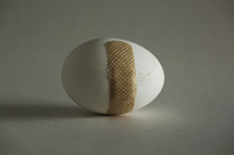 bandage around a cracked egg.