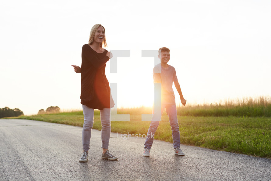 a mother and son dancing in the middle of the street 