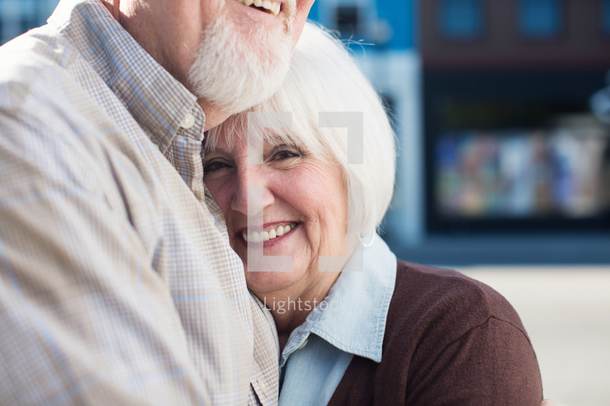 an elderly couple snuggling 