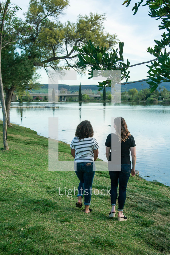 friends walking along a lake shore 