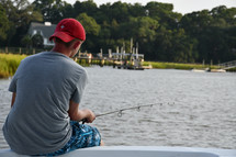 teen boy fishing off the side of a boat 