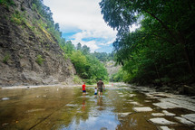 family walking through a river bed 