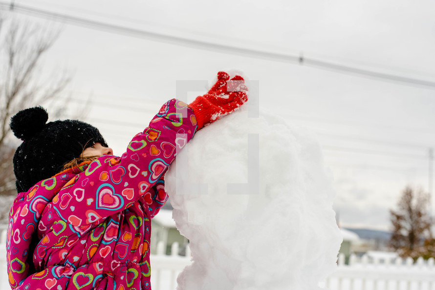 a child building a snowman 